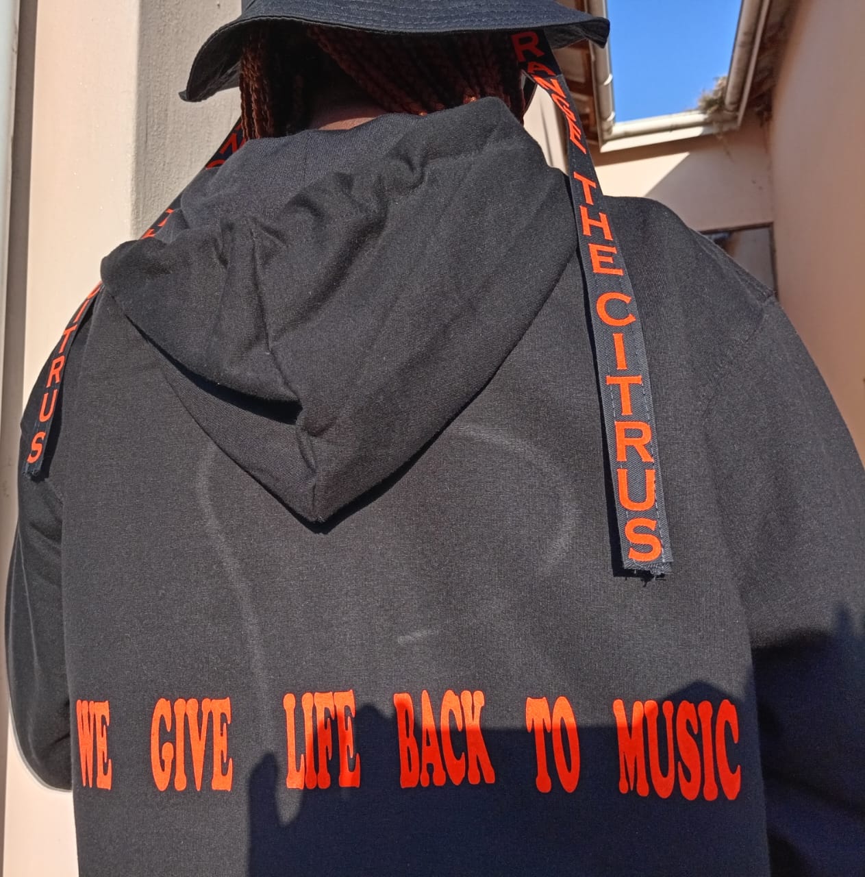 Back detail of an Orange The Citrus branded hoodie